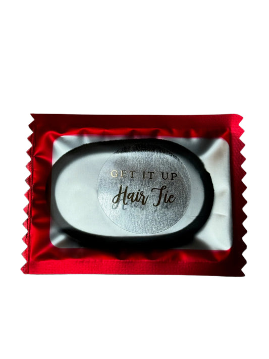 Black hair tie in a red packaging on a gray background